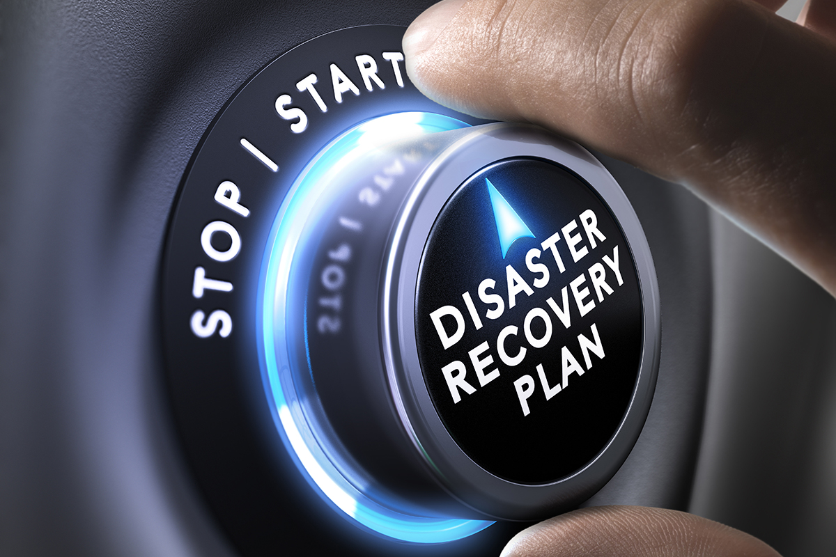 A hand turning a dial that reads Disaster Recovery Plan