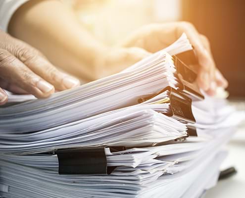 Businessman hands searching information in Stack of papers files on work in office business report.