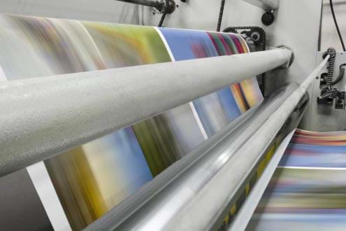 Close Up Pages Going Through Rollers of Printing Machine
