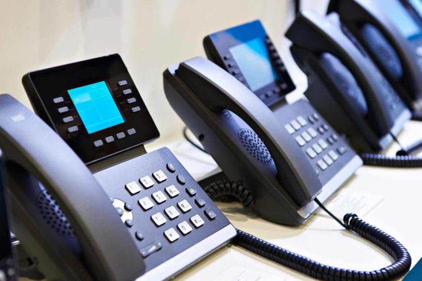 VoIP Business Phones in a Row on a Desk
